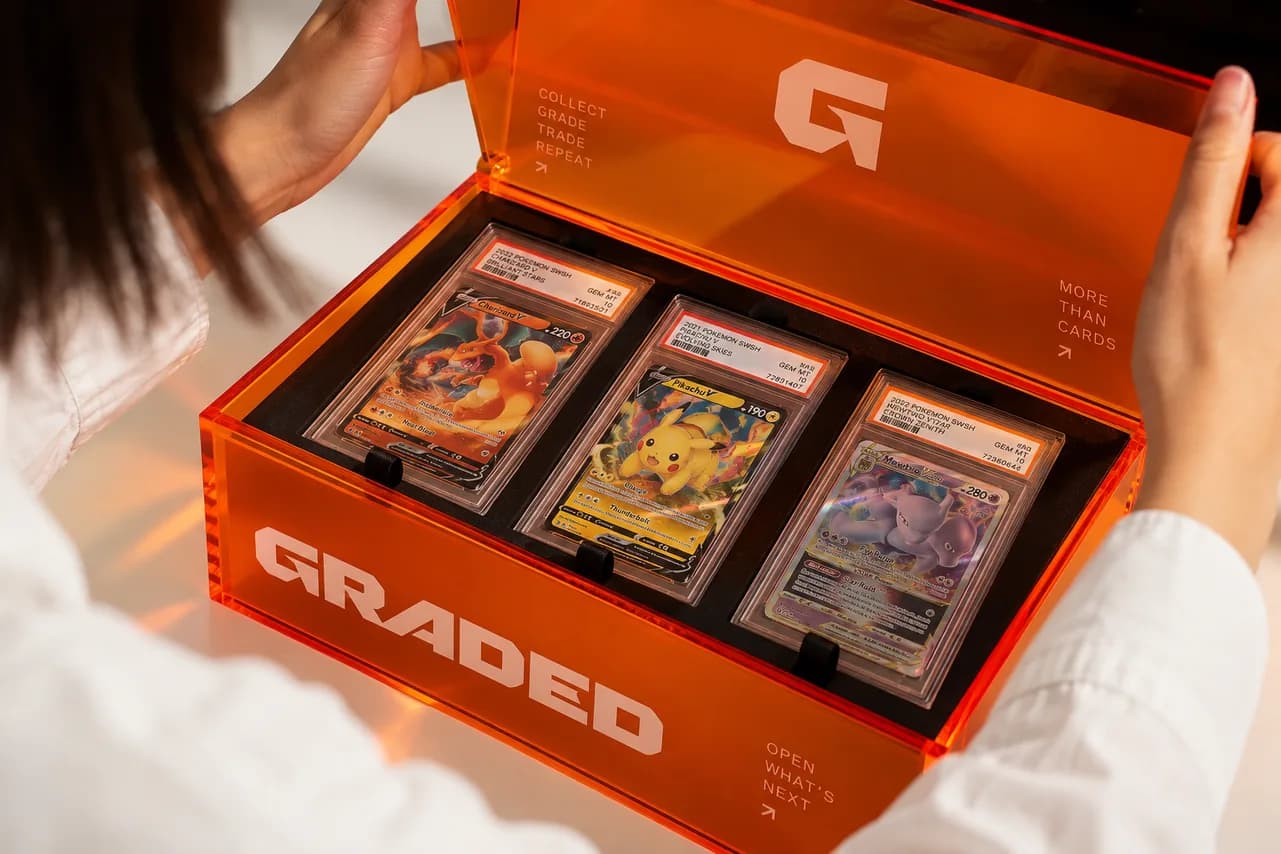 An opened Graded box holding three graded cards
